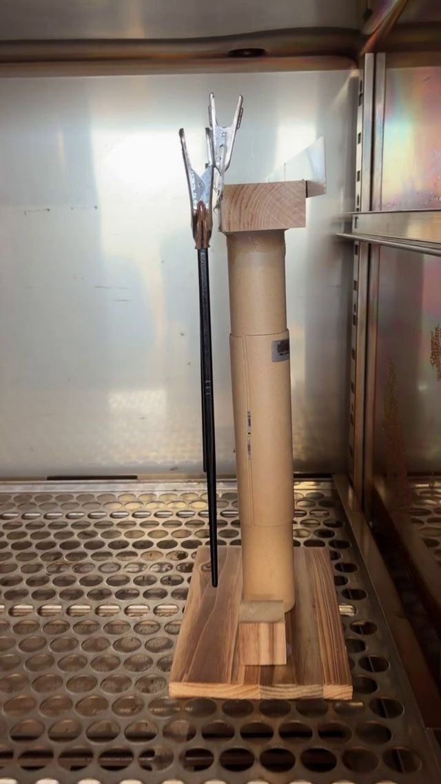Coated chopsticks on a clip rack inside the curing oven