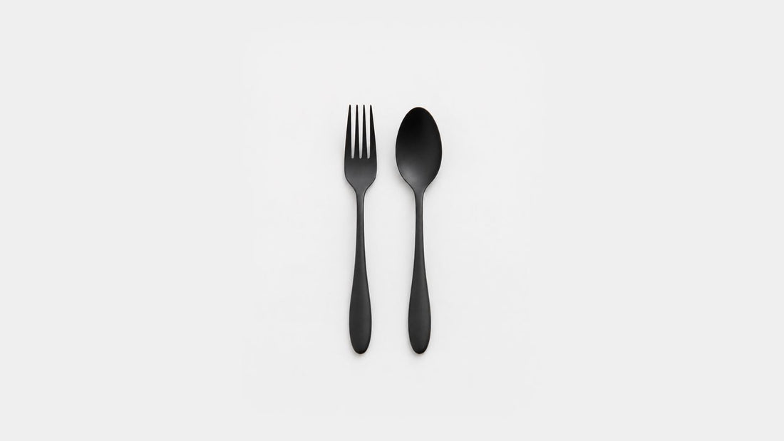 Teardrop-shaped black urushi stainless steel fork and spoon on a light background