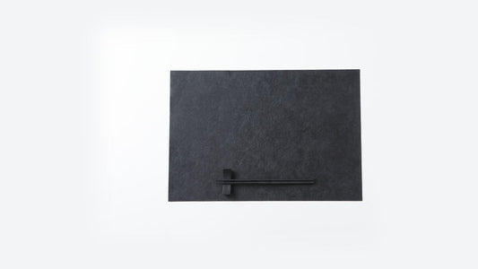 A dark urushi-finished washi placemat with black chopsticks laid on a chopstick rest
