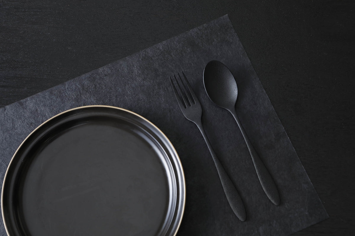 THE URUSHI stainless steel spoon and fork with urushi finish on a washi placemat